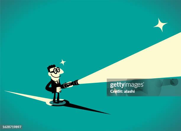 a businessman standing on a compass lights the way ahead with a flashlight - treasure hunt stock illustrations