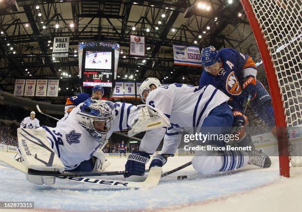 Goaltender James Reimer and defenseman Carl Gunnarsson of the Toronto Maple Leafs manage to stop Kyle Okposo of the New York Islanders in the first...