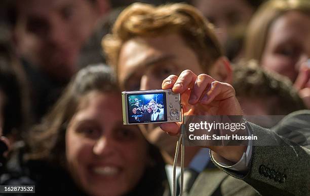 James Franco poses with the members of the public as he arrives for the "Oz: The Great And Powerful" European premiere at the Empire Leicester Square...