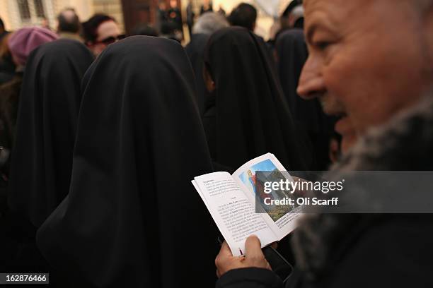 Pilgrims wait for Pope Benedict XVI to wave, for the last time as head of the Catholic Church, from the window of Castel Gandolfo where he will start...