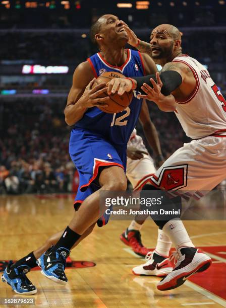 Evan Turner of the Phildelphia 76ers is fouled by Carlos Boozer of the Chicago Bulls at the United Center on February 28, 2013 in Chicago, Illinois....