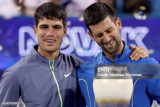 Carlos Alcaraz of Spain and Novak Djokovic of Serbia pose with their trophies after the final of the Western & Southern Open at Lindner Family Tennis...