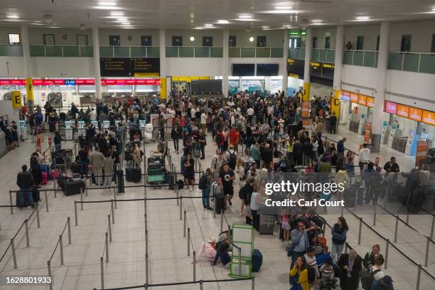 People wait near check-in desks at Gatwick Airport on August 28, 2023 in Crawley, United Kingdom. The United Kingdom's air traffic control systems...