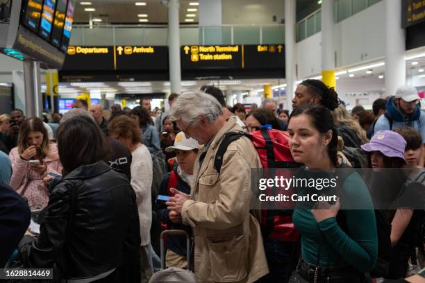 People wait near check-in desks at Gatwick Airport on August 28, 2023 in Crawley, United Kingdom. The United Kingdom's air traffic control systems...