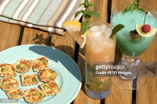 Summer Cocktails. Cocktails et bouchées : cocktails Edelweiss et Mahalia à côté d'une assiette de tartelettes aux légumes.