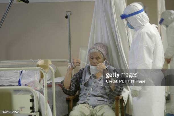Hong Kong City Of Fear. HONG KONG principal foyer du Syndrome respiratoire aigu sévère : un infirmier portant une tenue isolante venant aider une...