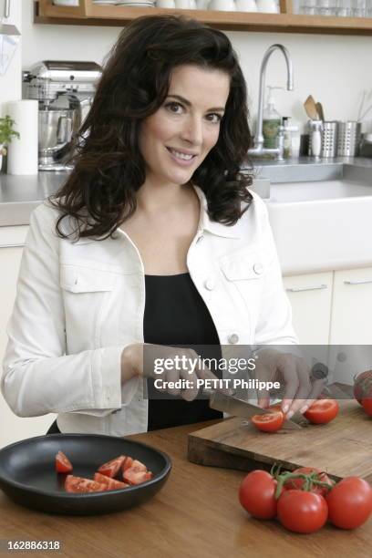 Renewal Of The English Cooking. Nigella LAWSON découpant des tomates en quartiers dans la cuisine d'un appartement à LONDRES.