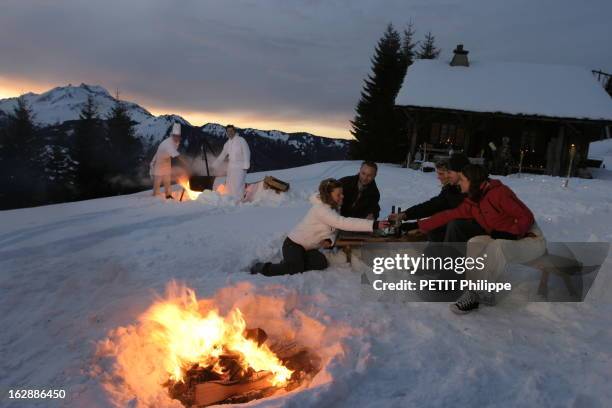 The Dromonts Hotel Of Christophe Leroy. Christophe LEROY et un cuisinier préparant un repas dans un chaudron sous un feu de bois, dans la neige,...