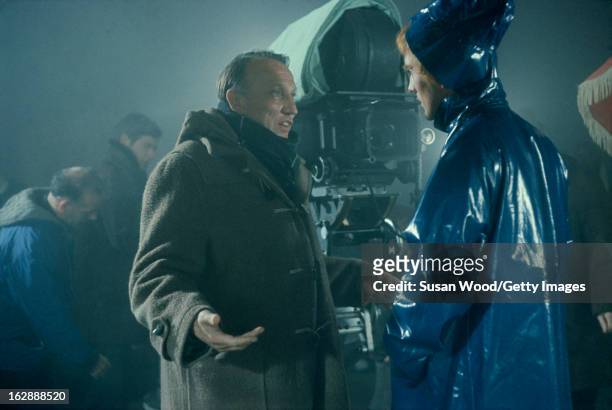 American-born British film director Joseph Losey gestures as he talks with and English actor Terence Stamp on the set of the film 'Modesty Blaise,'...
