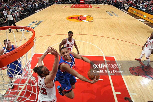 Evan Turner of the Philadelphia 76ers goes up for the layup against Joakim Noah of the Chicago Bulls on February 28, 2013 at the United Center in...