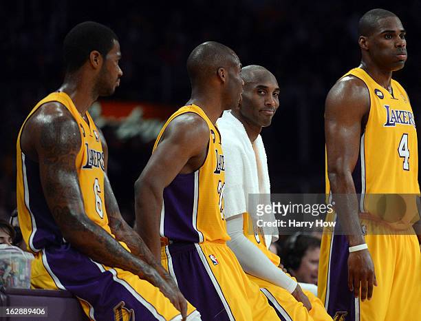 Kobe Bryant of the Los Angeles Lakers smiles on the sideline with Earl Clark, Jodie Meeks and Antawn Jamison during a 116-94 Laker win over the...