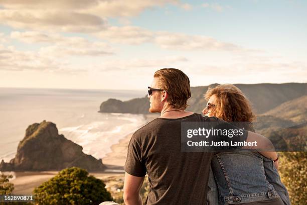 couple looks at view of piha beach new zealand - summer new zealand fotografías e imágenes de stock