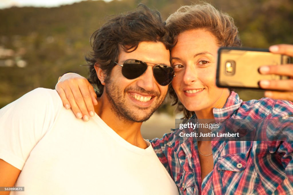 COUPLE TAKING A SELF-PORTRAIT INTO THE SUNLIGHT