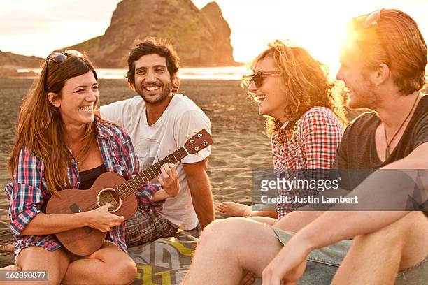 group of friends enjoying the sunset at the beach - nz summer bildbanksfoton och bilder