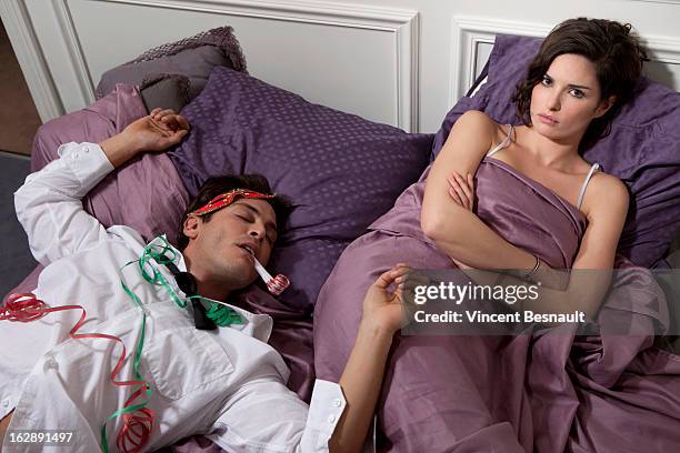 couple in bed, the man drunk - woman after party stockfoto's en -beelden