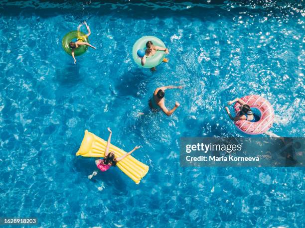 friends having fun while playing with ball in the swimming pool. aerial view. - poolparty stockfoto's en -beelden