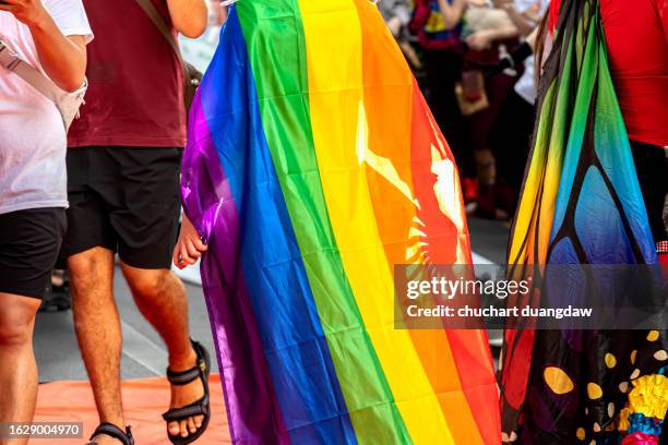 gay pride parade- pride month and parade-people marching with the rainbow lgbtq+ flag in bangkok - rainbow flag stock pictures, royalty-free photos & images