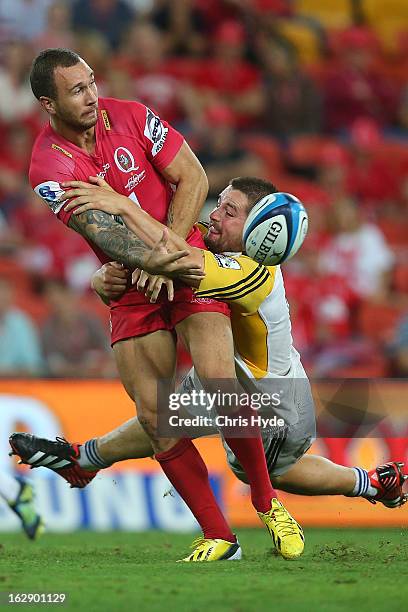 Quade Cooper of the Reds is tackled by Dane Coles of the Hurricanes during the round three Super Rugby match between the Reds and the Hurricanes at...