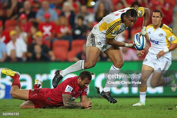 Julian Savea of the Hurricanes makes a run past Quade Cooper of the Reds during the round three Super Rugby match between the Reds and the Hurricanes...