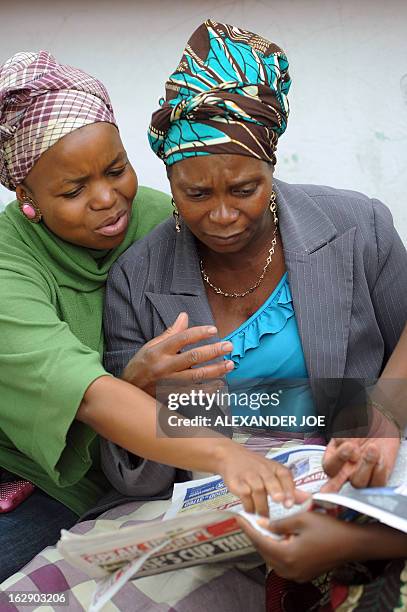 Relatives look on March 1, 2013 at the local newspaper that published photos of Mido Macia, the taxi driver who was dragged to death by South African...