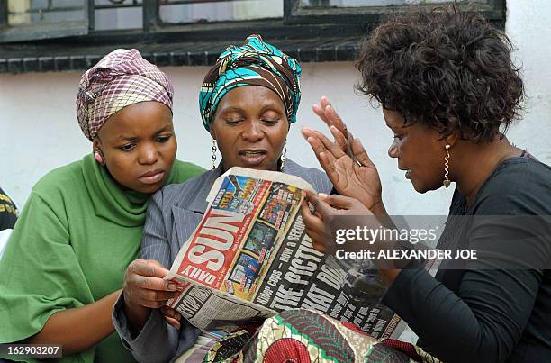 Relatives look on March 1, 2013 at the local newspaper that published photos of Mido Macia, the taxi driver who was dragged to death by South African...