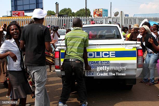 Protestors outside the Daveyton Police station on February 28, 2013 in Daveyton, South Africa. A Mozambican taxi driver, Mido Macia was handcuffed to...