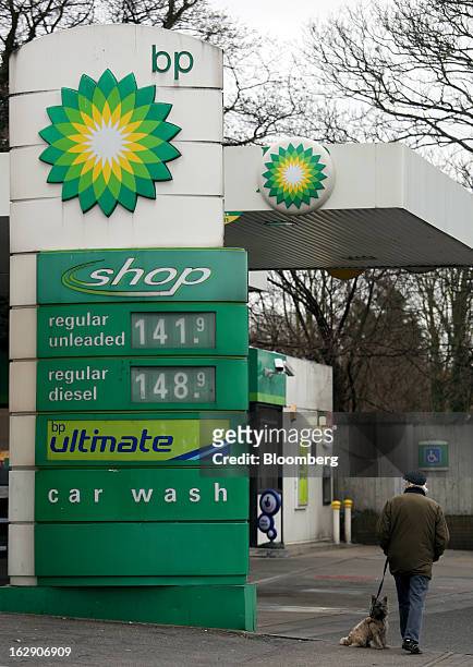 Pedestrian walks with a dog as they pass a BP gas station, operated by BP Plc, in Hornchurch, U.K., on Thursday, Feb. 28, 2013. BP Plc's push to...