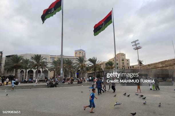 Libyans gather at the Martyrs' Square in Tripoli on August 28, 2023 following protests against an informal meeting between the country's foreign...