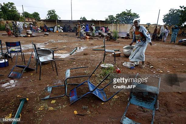 Woman collects debris 05 June 2007 near the "Babemba Traore" stadium in Sikasso, Mali, after a strong storm destroyed tents used during a forum to...