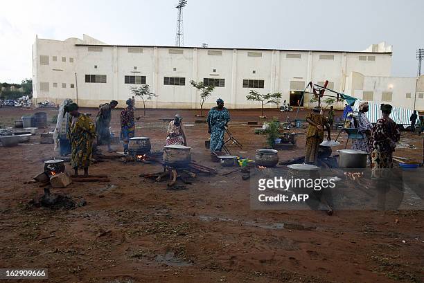 Women collect debris 05 June 2007 near the "Babemba Traore" stadium in Sikasso, Mali, after a strong storm destroyed tents used to gather food during...