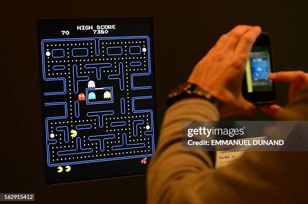 Visitor takes a picture of the video game Pac-Man during an exhibition preview featuring 14 video games acquired by The Museum of Modern Art in New...