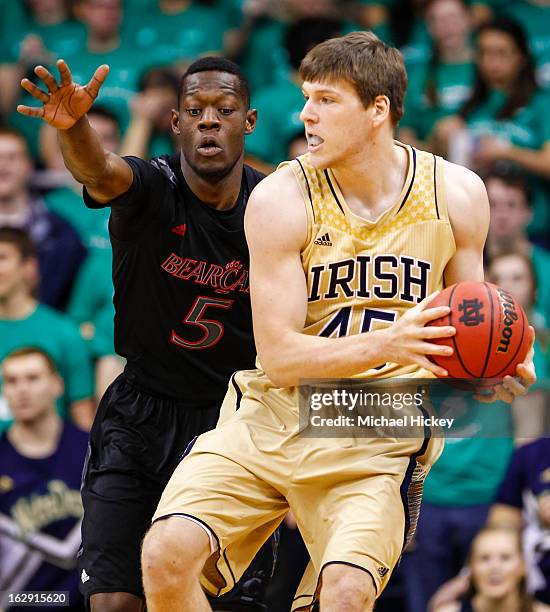 As Justin Jackson of the Cincinnati Bearcats guards Jack Cooley of the Notre Dame Fighting Irish holds the ball at Purcel Pavilion on February 24,...
