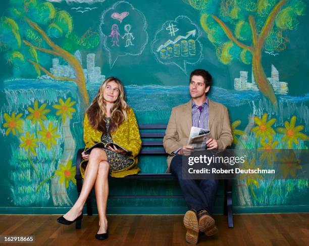 a man and woman sitting on a park bench. - juxtaposition stock-fotos und bilder