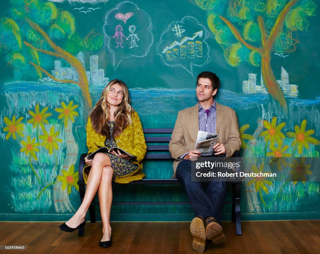 A man and woman sitting on a park bench.