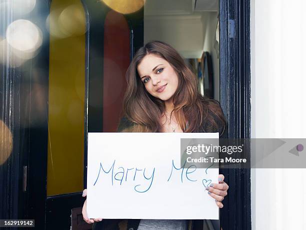 woman holding sign saying "marry me?" - engagement stock pictures, royalty-free photos & images