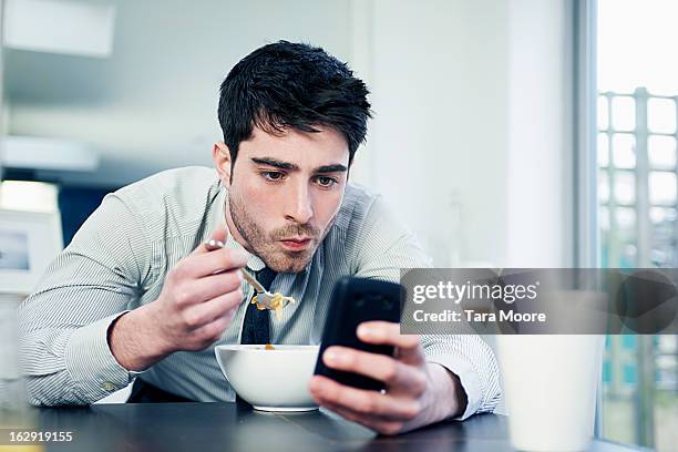 business man eating breakfast with mobile - eating on the move stock pictures, royalty-free photos & images