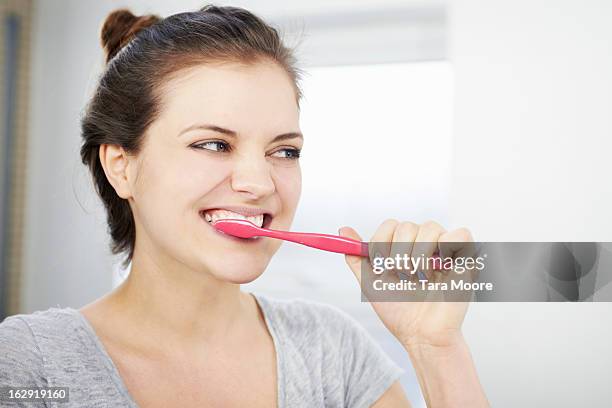 woman brushing teeth in bathroom - brush teeth stock pictures, royalty-free photos & images