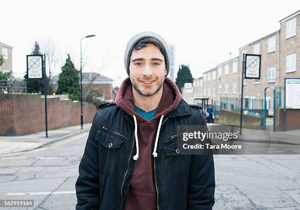 young man smiling to camera in urban street - 22 years old stock-fotos und bilder