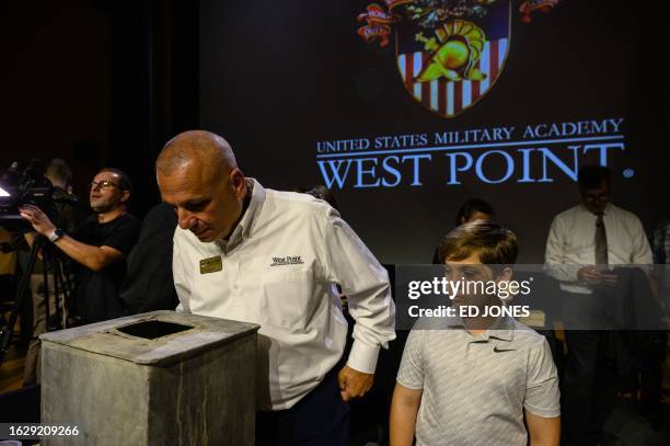 People look into a nearly 200-year-old time capsule during a ceremony in the Robinson Auditorium at Thayer Hall of the US Military Academy in West...