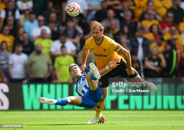Craig Dawson of Wolverhampton Wanderers is challenged by Julio Enciso of Brighton & Hove Albion during the Premier League match between Wolverhampton...