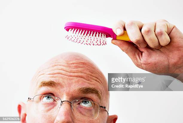 homem careca tentativas para lavar o cabelo inexistente - ironia imagens e fotografias de stock