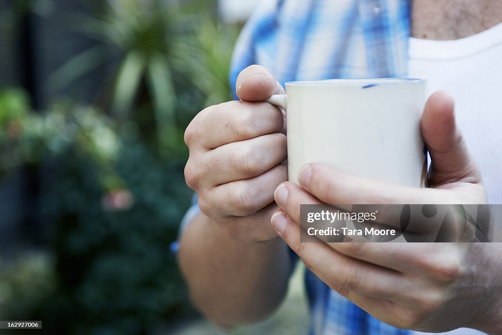 Close up of hands holding cup of coffee