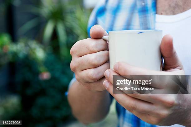 close up of hands holding cup of coffee - man mid 20s warm stock pictures, royalty-free photos & images