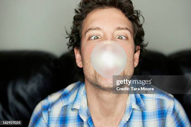 man going cross-eyed blowing chewing gum bubble - bubble gum man stock pictures, royalty-free photos & images