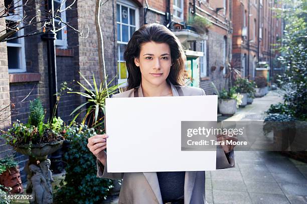 woman holding blank sign outside - person holding blank sign fotografías e imágenes de stock