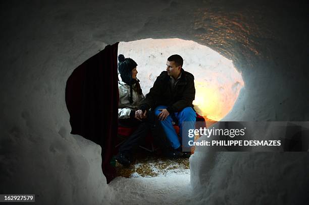 Young couple are about to sleep in an igloo on February 23, 2013 in a village of igloos at the Le Semnoz village, French Alps. AFP PHOTO / PHILIPPE...