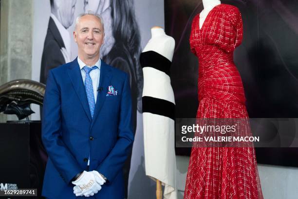 Martin Nolan, executive director, Chief Financial Officer, and a principal of Julien's Auctions, poses in front poses for a photo in front of dresses...