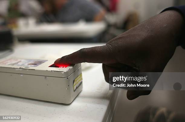 Recently-arrived refugee from Somalia gives a finger print during a class held by the Arizona Department of Economic Security at the International...