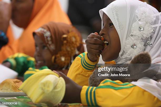 Child eats a snack as her parents, recently-arrived refugee from Somalia, learn how to receive food stamps during a class held by the Arizona...