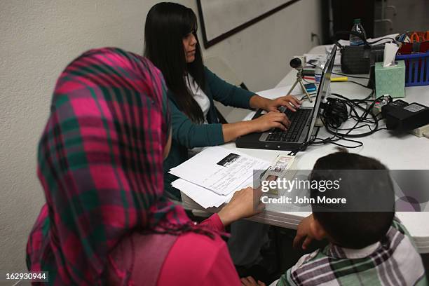 Recently-arrived refugee from Iraq gives a finger print during a class held by the Arizona Department of Economic Security at the International...